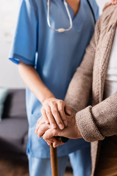 depositphotos_426794538-stock-photo-cropped-view-nurse-touching-hands